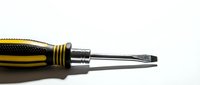 Professional yellow and black handle screwdriver with flathead tip isolated on white background for tool and hardware projects.