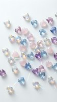 Collection of colorful heart-shaped gemstones in pink, blue and purple tones scattered on white background for jewelry design and luxury accessories.