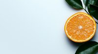 Fresh juicy orange cut in half with green leaves on light background, minimalist food composition with copy space for healthy lifestyle designs.