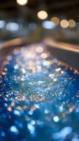 Abstract blue and gold bokeh background with glittering water surface and defocused lights creating magical dreamy atmosphere for festive designs.