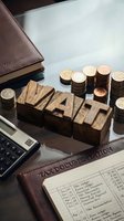 Wooden TAX letters with coins, calculator and documents on desk for accounting, finance planning and tax preparation services.