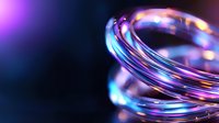 Luminous spiral rings with neon purple and blue glow against dark background create futuristic abstract composition for technology and innovation concepts.