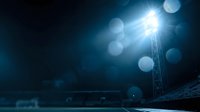 Bright stadium floodlight illuminating sports field at night with dramatic lens flare and bokeh effects creating atmospheric lighting for evening games.