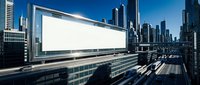 Large blank white billboard on modern urban highway with skyscrapers and blue sky, mockup for outdoor advertising display.