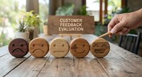 Customer feedback evaluation concept with wooden emoji faces showing satisfaction levels from negative to positive on rustic table for business rating.