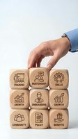 Business professional hand selecting wooden blocks with HR and employee development icons for corporate training and management strategy concepts.