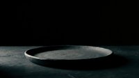 Empty concrete plate on dark textured surface for product display, food styling, and minimalist design projects.