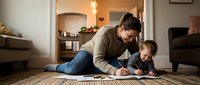 Young Caucasian mother and toddler son drawing together on floor in cozy living room. Family bonding time, early childhood education and creativity.