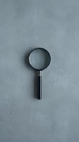 Magnifying glass with black handle on gray textured background, representing search, investigation, analysis, and discovery for business and research applications.
