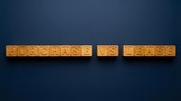 Purchase vs lease wooden blocks on dark blue background for business decision and financial comparison concepts.