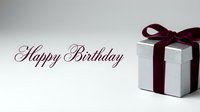 Happy Birthday elegant greeting card with silver gift box and dark red velvet ribbon bow on light background for celebration design.