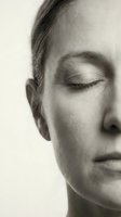 Serene young woman with closed eyes in peaceful meditation pose. Black and white portrait showcasing natural beauty and tranquil expression for wellness concepts.