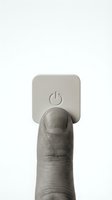 Finger pressing power button on wall switch, turning on or off electrical device for home automation and energy control.
