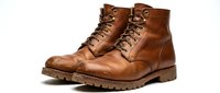Brown leather work boots with lace-up design and rugged sole isolated on white background for fashion and footwear projects.