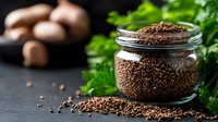 Ground coffee granules in glass jar with fresh parsley leaves and whole coffee beans on dark background, macro food photography for cafe menu or blog.