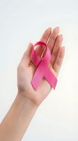 Hand holding pink ribbon symbol for breast cancer awareness campaign and women health support on white background.
