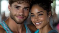 Young diverse couple smiling at camera, close up portrait showing genuine happiness and connection. Mixed race relationship captured in natural lighting with soft bokeh background.