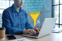 Young businessman analyzing data conversion funnel on laptop with digital marketing analytics overlay in modern office workspace for business intelligence.