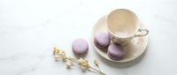 Lavender macarons with an elegant ceramic cup on a marble surface, decorated with dried flowers, soft pastel tones for a delicate tea time concept.