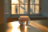 Luxurious face cream jar on wooden surface in warm morning sunlight with window shadows, creating elegant beauty product photography atmosphere.