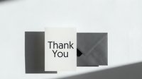 Minimalist thank you card with gray envelope on white surface, soft shadows, clean typography, elegant stationery for gratitude messages.