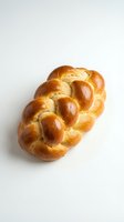 Golden braided challah bread loaf with glossy crust isolated on white background for bakery and food design projects.