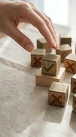 Hand placing a wooden block with green checkmark among blocks with red crosses on linen surface, symbolizing right choice and decision making.