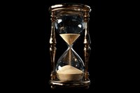Vintage brass hourglass with golden sand flowing through glass bulbs on black background. Time management and deadline concept for business presentations.