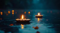 Floating oil lamps with warm flames create peaceful ambiance on dark water surface during evening celebration or spiritual ceremony with glowing reflections.