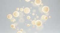 Golden oil bubbles floating on water surface with soft bokeh lighting effects creating luxurious spa and wellness atmosphere for cosmetic product backgrounds.