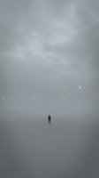 Solitary figure standing in vast misty landscape with ethereal glowing lights floating in foggy atmosphere, conveying isolation, mystery, and contemplation for conceptual and editorial use.