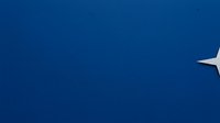 Airplane wing against deep blue sky during flight, aerial view for travel and aviation concepts.