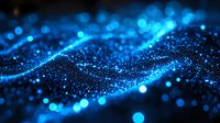 Glowing blue particles form dynamic waves against dark background, creating futuristic network visualization effect for technology and data concepts.