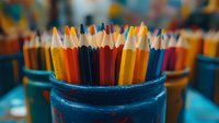 Colorful wooden pencils standing in blue holder against blurred background. Close-up view captures vibrant shades and textures for education and creativity concepts.