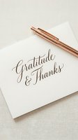 Elegant gratitude and thanks calligraphy card with rose gold pen on neutral background for thanksgiving, appreciation and mindfulness concepts.