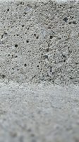 Rough porous concrete surface with holes and weathered texture for industrial construction and architectural backgrounds.