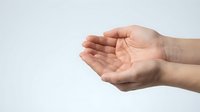 Open cupped hands gesture showing palms in receiving position against clean white background for presentations and charity concepts.