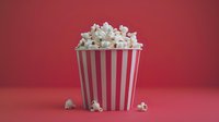 Fresh popcorn overflowing from classic red and white striped container against vibrant pink background, with scattered kernels creating casual cinema mood.