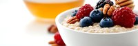 Healthy breakfast bowl with oatmeal topped with fresh berries, nuts and honey. Nutritious morning meal for wellness and energy boost lifestyle.