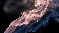 Abstract colorful smoke swirls in pink and blue hues with golden particles on dark background for creative design projects and artistic compositions.