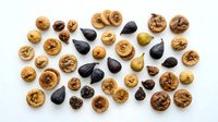 Assorted nuts and dried fruits including walnuts, almonds, raisins, and dates arranged on white background, isolated for design, packaging, and culinary projects.