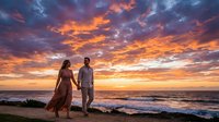 Couple in elegant attire standing on beach at sunset, holding hands while watching golden sky and ocean waves. Romantic scene for wedding, engagement, or travel content.
