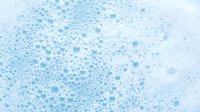Abstract blue watercolor texture with scattered dots and bubbles creating organic flowing pattern for backgrounds and creative design projects.