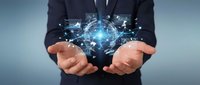 Professional businessman in dark suit holding glowing digital network connections and data visualization above cupped hands representing technology innovation.