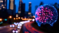 Glowing digital sphere with binary code pattern against blurred city traffic lights and skyscrapers at dusk, creating futuristic urban technology concept.