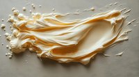 Creamy caramel splash with flowing liquid texture and droplets on light surface, dynamic food photography showing smooth swirls and waves in golden hues.