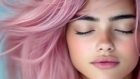 Young woman with closed eyes and flowing pink hair in peaceful expression for beauty and wellness concepts.