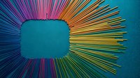 Colorful rainbow gradient rays burst from central teal square frame on textured blue background creating dynamic radial sunburst pattern for modern design projects.