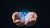 Cupped hands holding glowing blue heart with light rays on dark background symbolizing love, care, protection, and compassion in healthcare concept.