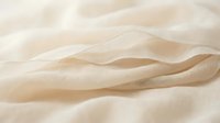 Smooth wooden stick resting on soft beige fabric with gentle folds, showcasing natural texture and minimalist composition for design and lifestyle projects.